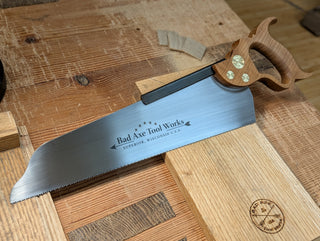 a 14 inch half back saw with a cherry handle made by bad axe tool works